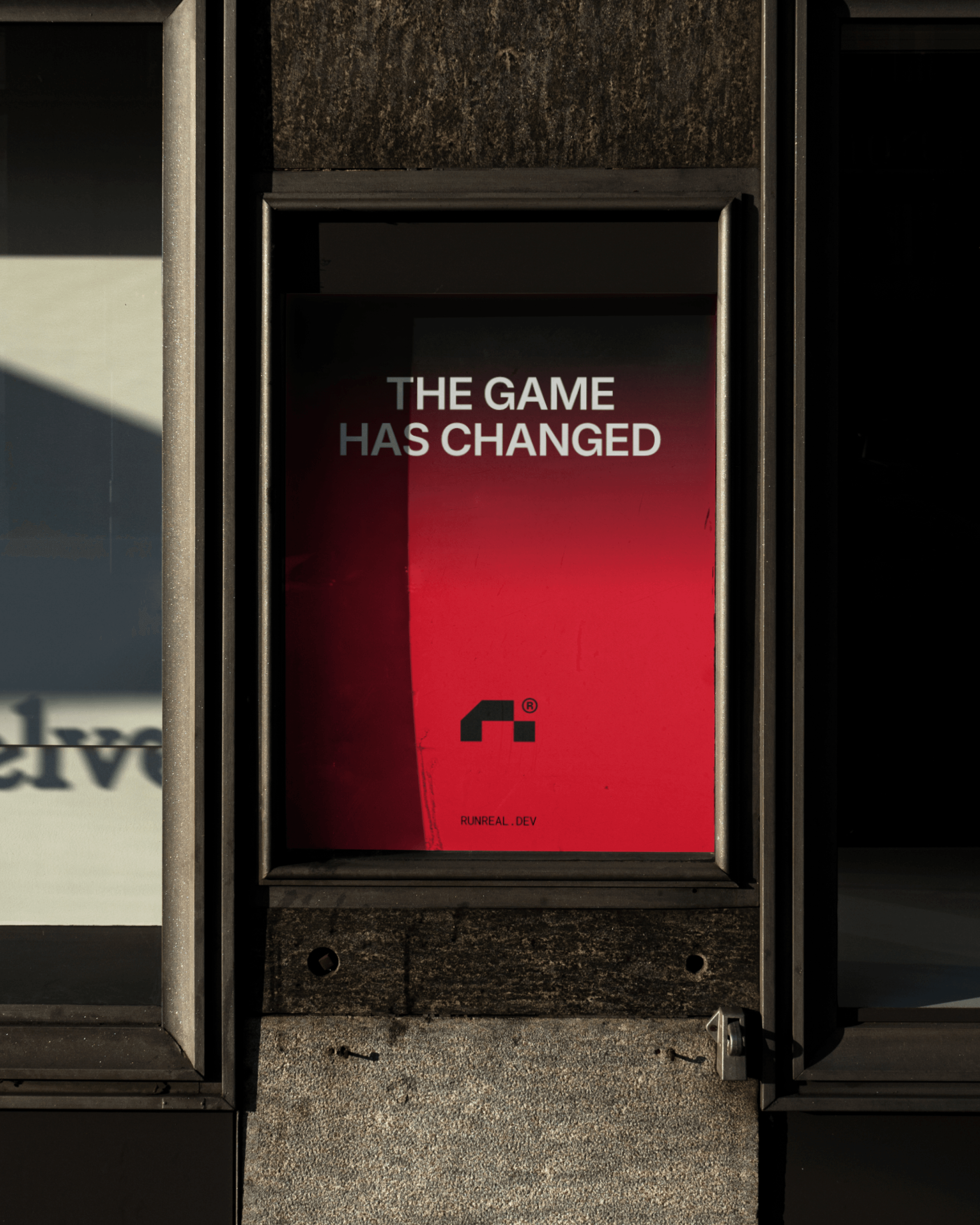 Street poster mockup for Runreal with bold red gradient background and the headline “THE GAME HAS CHANGED,” showcasing Kundo Studio’s tech-forward brand identity, typography, and out-of-home launch visuals for the Runreal rebrand.